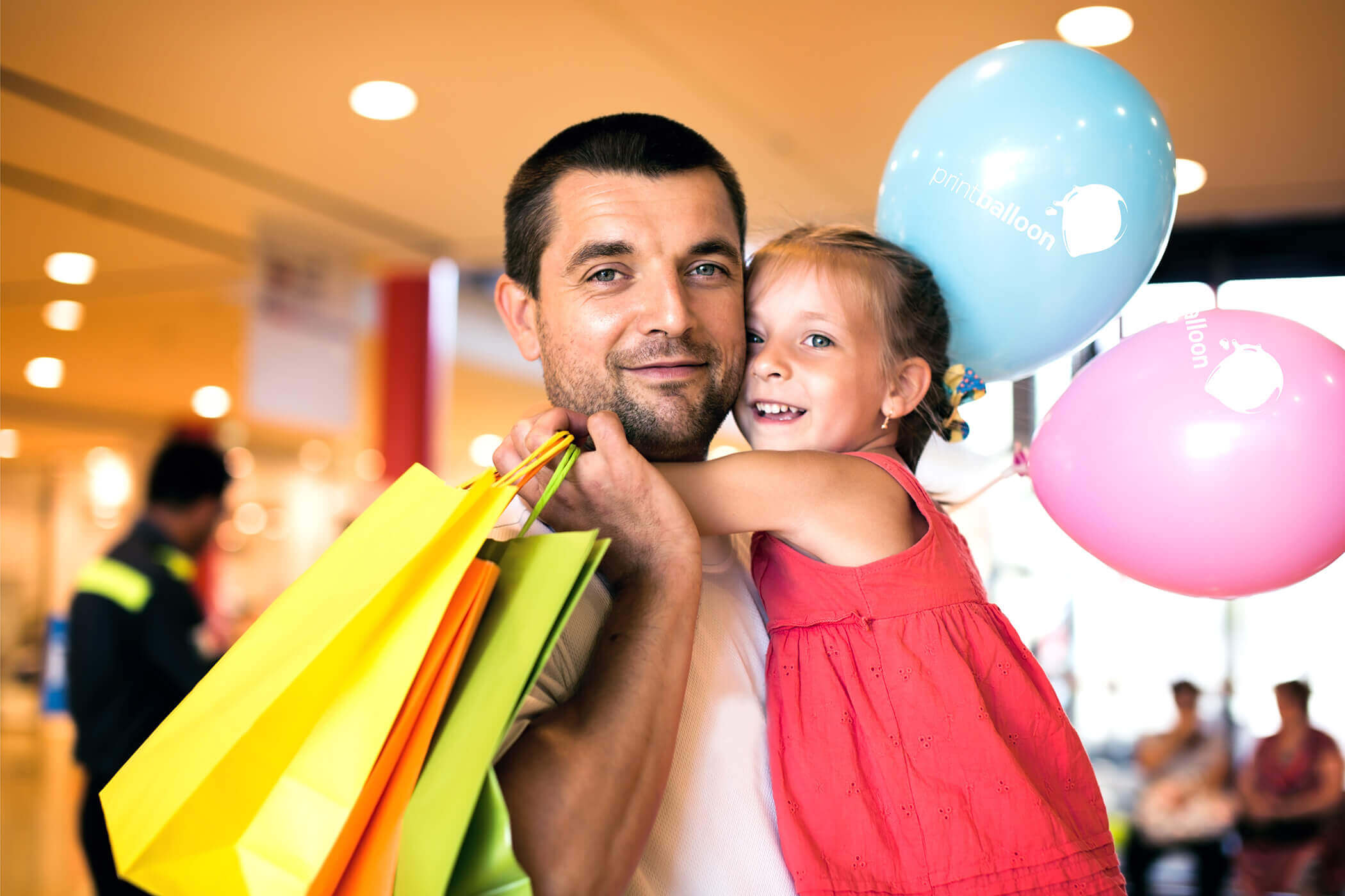 pai e filha abraçados segurando balões personalizados